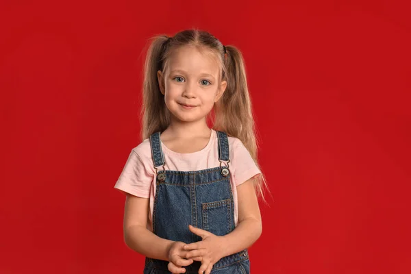 Porträt des niedlichen kleinen Mädchens auf rotem Hintergrund — Stockfoto