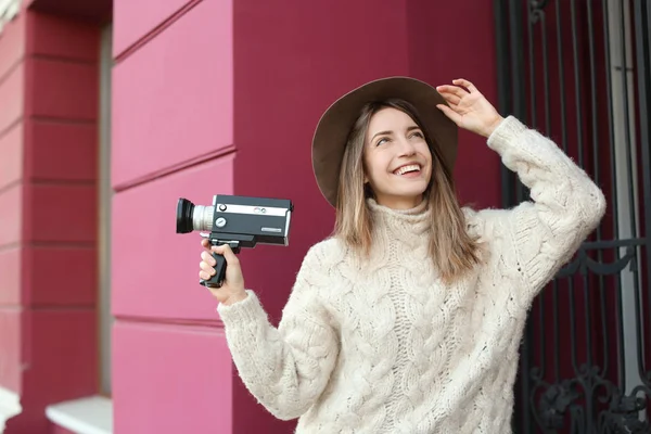 Mulher bonita com câmera de vídeo vintage na rua da cidade — Fotografia de Stock