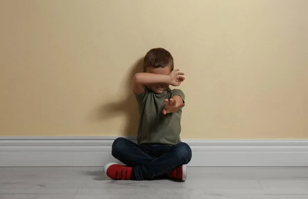 Φοβισμένο Αγοράκι Που Κλείνει Χέρι Στο Πάτωμα Κοντά Στον Κίτρινο — Φωτογραφία Αρχείου