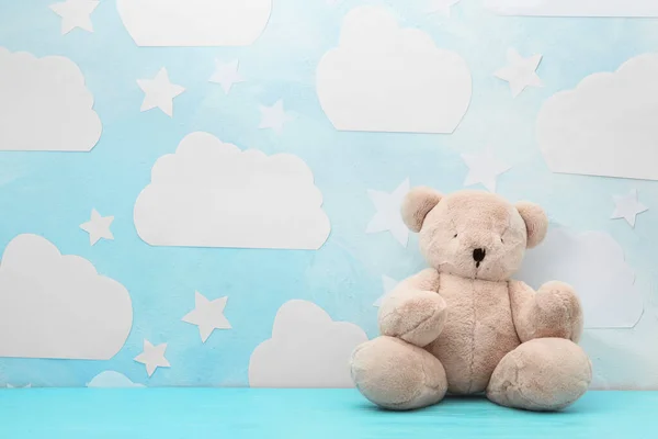 Teddy bear on wooden table near wall with blue sky, space for te — Stock Photo, Image