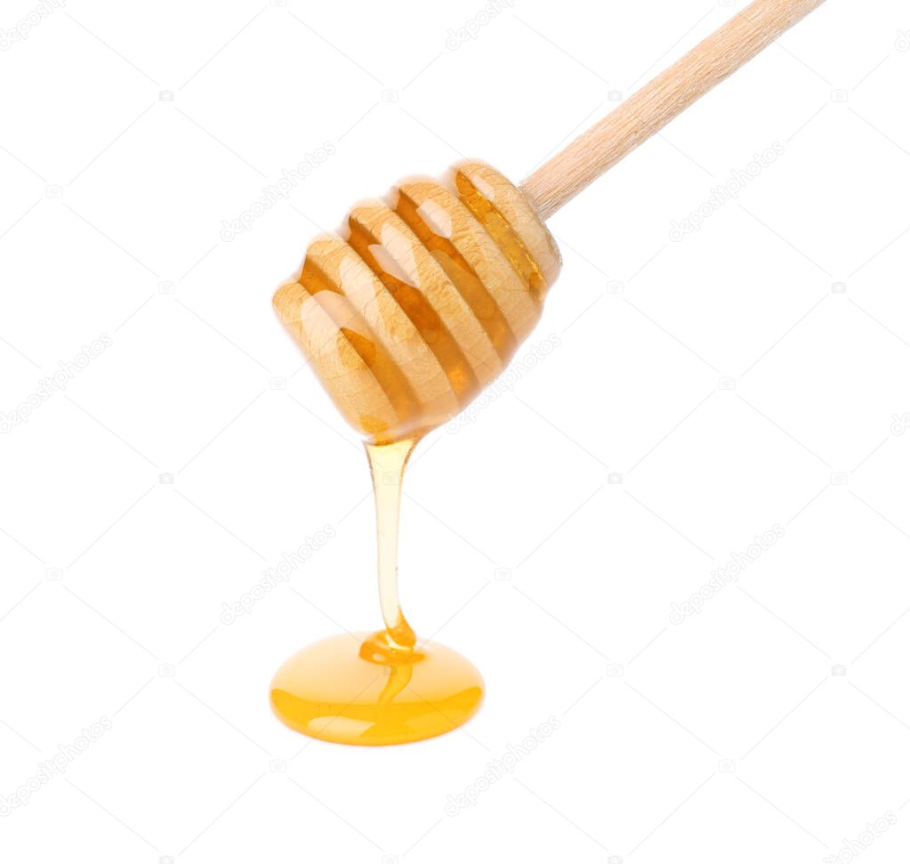 Honey pouring from wooden dipper isolated on white