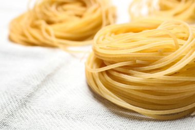 Beyaz masa örtüsü üzerinde Capellini makarnası, yakın çekim görünümü