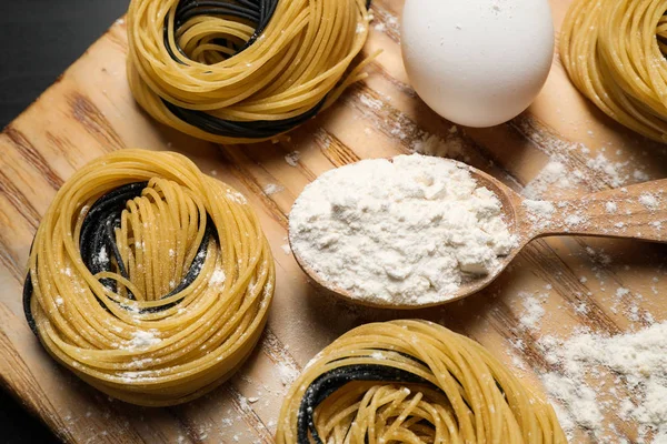 Pastas y productos de linguine crudo sobre tabla de madera, planas — Foto de Stock