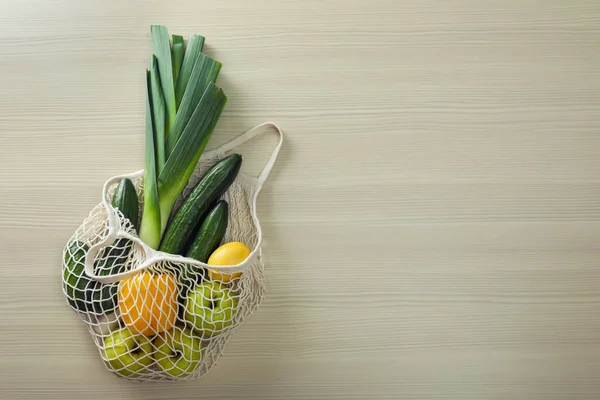Čistá taška se zeleninou a ovocem na dřevěném stole, výhled shora. Sp — Stock fotografie