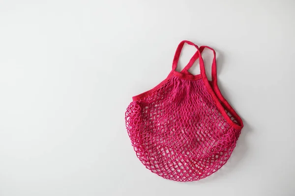 Empty pink net bag on white background, top view. Space for text — Stock Photo, Image