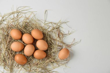 Çiğ tavuk yumurtası ve dekoratif pipet beyaz masada, düz yerde. Metin için boşluk