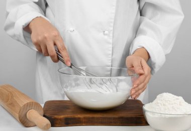 Ahşap masada yumurta beyazı çırpan kadın, yakın plan. Pasta yapmak.
