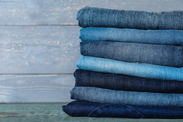 Stapel Verschillende Jeans Blauwe Houten Tafel — Stockfoto