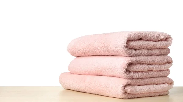 Folded fresh clean towels for bathroom on table against white ba — 图库照片