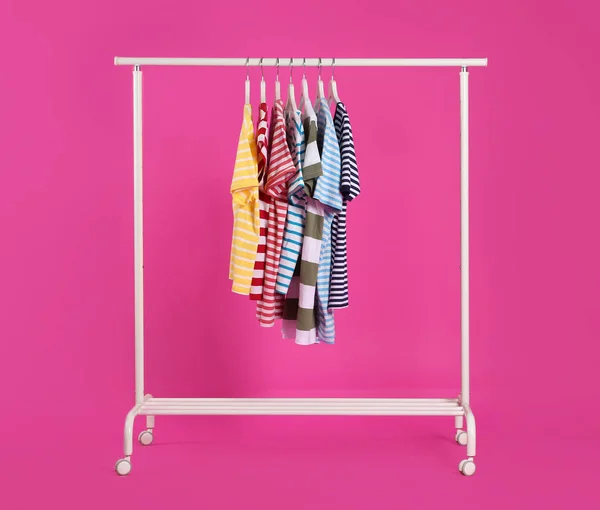 Kleurrijke Kleding Opknoping Rek Tegen Roze Achtergrond — Stockfoto