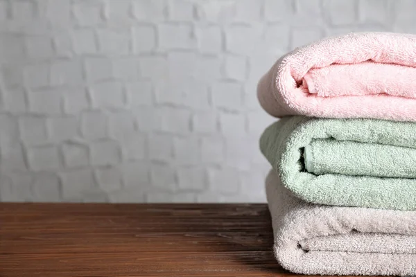 Pilha de toalhas de banho limpas na mesa de madeira. Espaço para texto — Fotografia de Stock