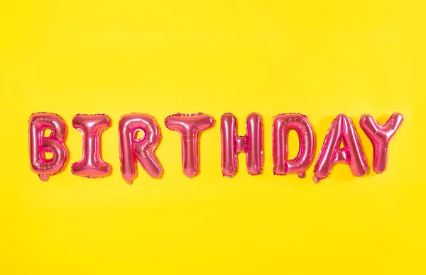 Word Urodziny Wykonane Różowej Folii Balony Litery Żółtym Tle — Zdjęcie stockowe