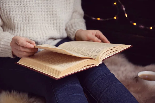 Молодая женщина читает книгу дома, крупным планом — стоковое фото