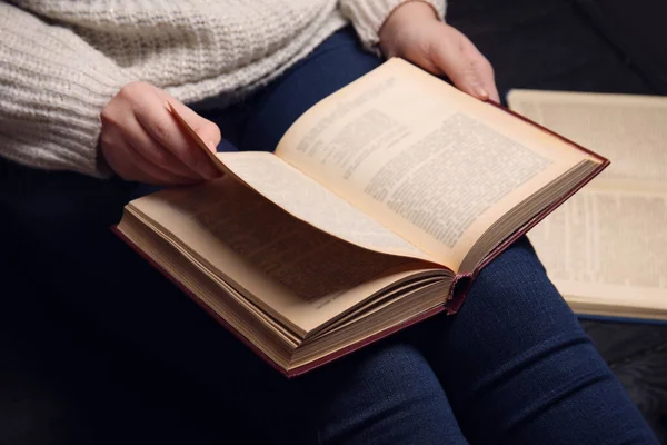 Молода жінка читає книгу вдома, крупним планом — стокове фото