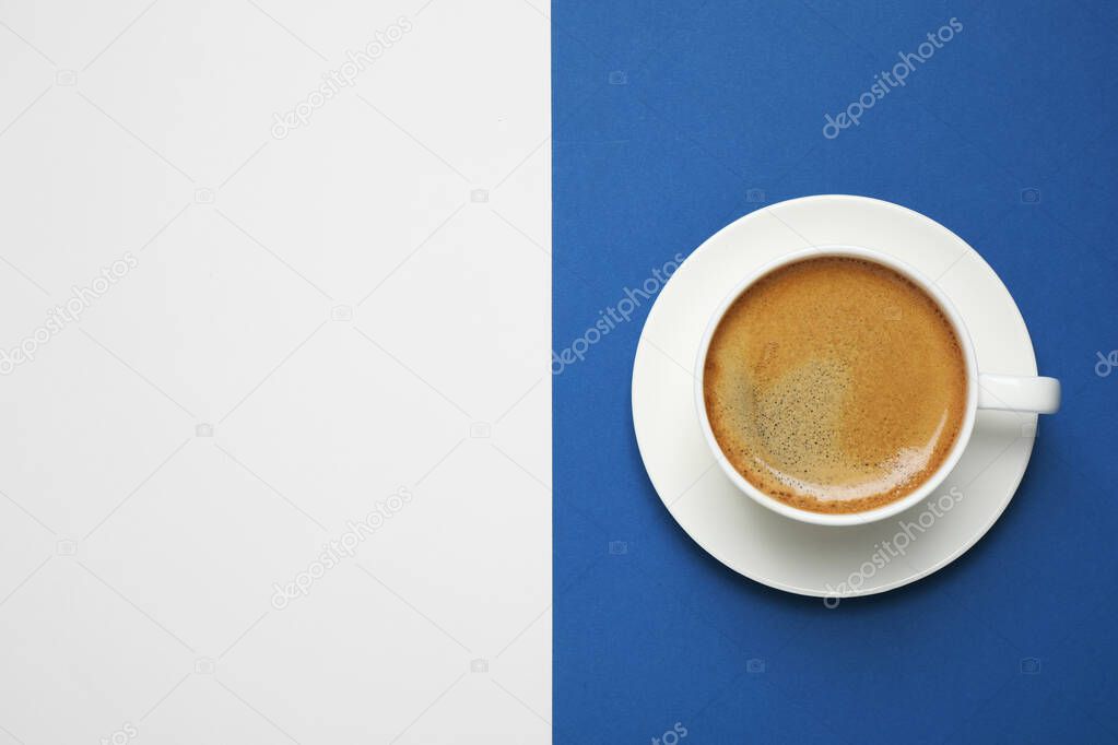 Black coffee on bright background, top view with space for text. Color of the year 2020 (Classic blue)
