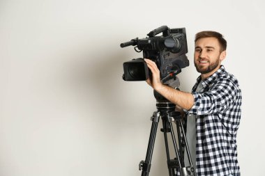 Beyaz arkaplanda profesyonel video kamerası olan operatör