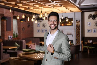 Genç işyeri sahibi kafesinde duruyor.