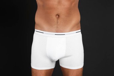 İç çamaşırlı adam siyah arka planda, yakın plan.