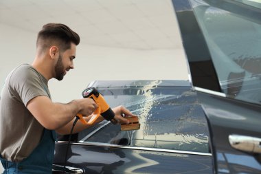 Atölyede ısı tabancasıyla araba boyama