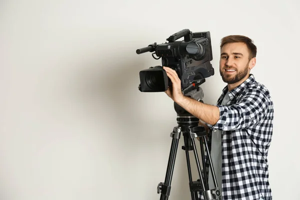 Bediener mit professioneller Videokamera auf weißem Hintergrund — Stockfoto