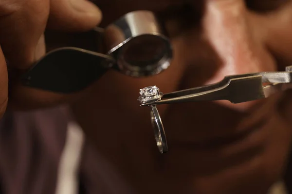 Professional jeweler evaluating beautiful ring, closeup view — Stock Photo, Image