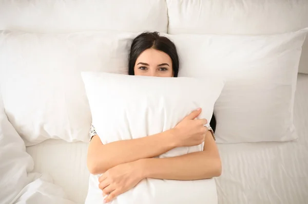 Mladá žena s polštářem v posteli, výhled shora. Líné ráno — Stock fotografie
