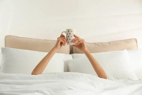 Žena s šálkem kávy v posteli, detailní záběr. Líné ráno — Stock fotografie