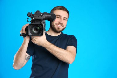 Mavi arkaplanda profesyonel video kamerası olan operatör