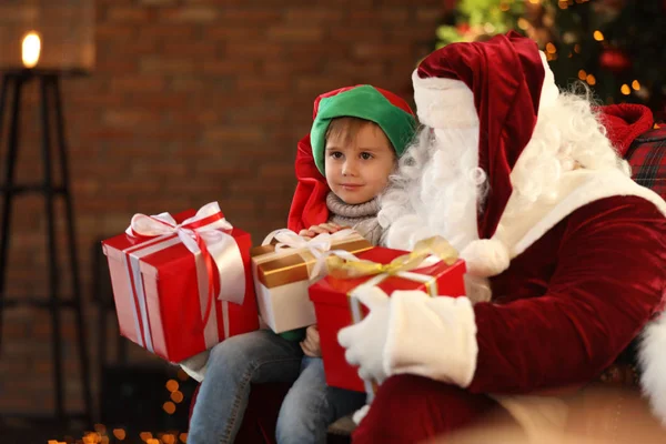 Papá Noel y niño pequeño con regalos de Navidad en el interior — Foto de Stock