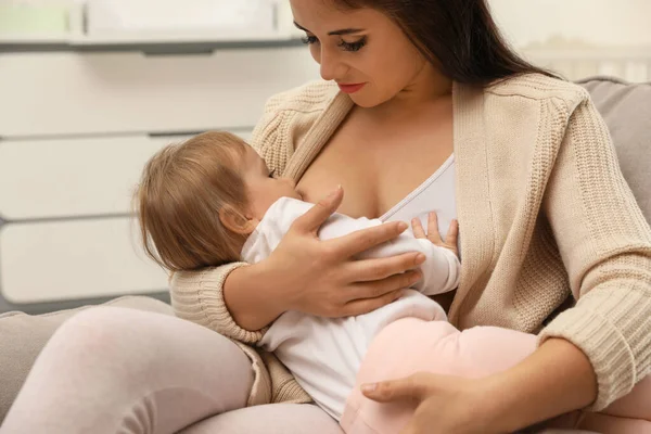 Mulher amamentando seu bebê em casa — Fotografia de Stock