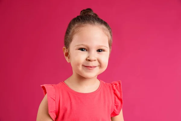 Portrét roztomilé holčičky na růžovém pozadí — Stock fotografie