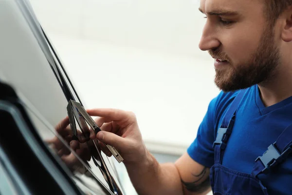 Worker tinting car window with foil in workshop — Stock Photo, Image