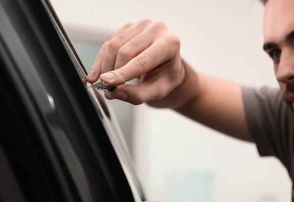 Worker tinting car window with foil in workshop, closeup — Stock Photo, Image