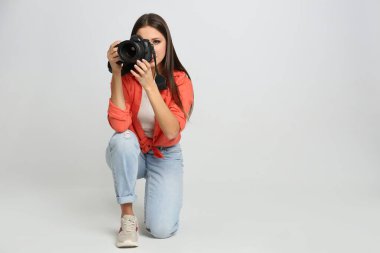 Stüdyoda beyaz arka plan üzerinde çalışan profesyonel fotoğrafçı.