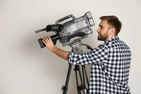 Operador com câmera de vídeo profissional em fundo branco — Fotografia de Stock