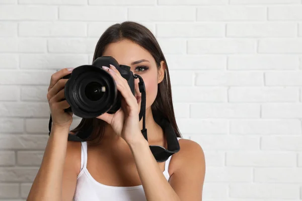 Fotógrafo profesional trabajando cerca de la pared de ladrillo blanco en studi —  Fotos de Stock