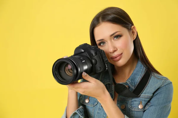 Fotógrafo profissional trabalhando em fundo amarelo em estúdio — Fotografia de Stock