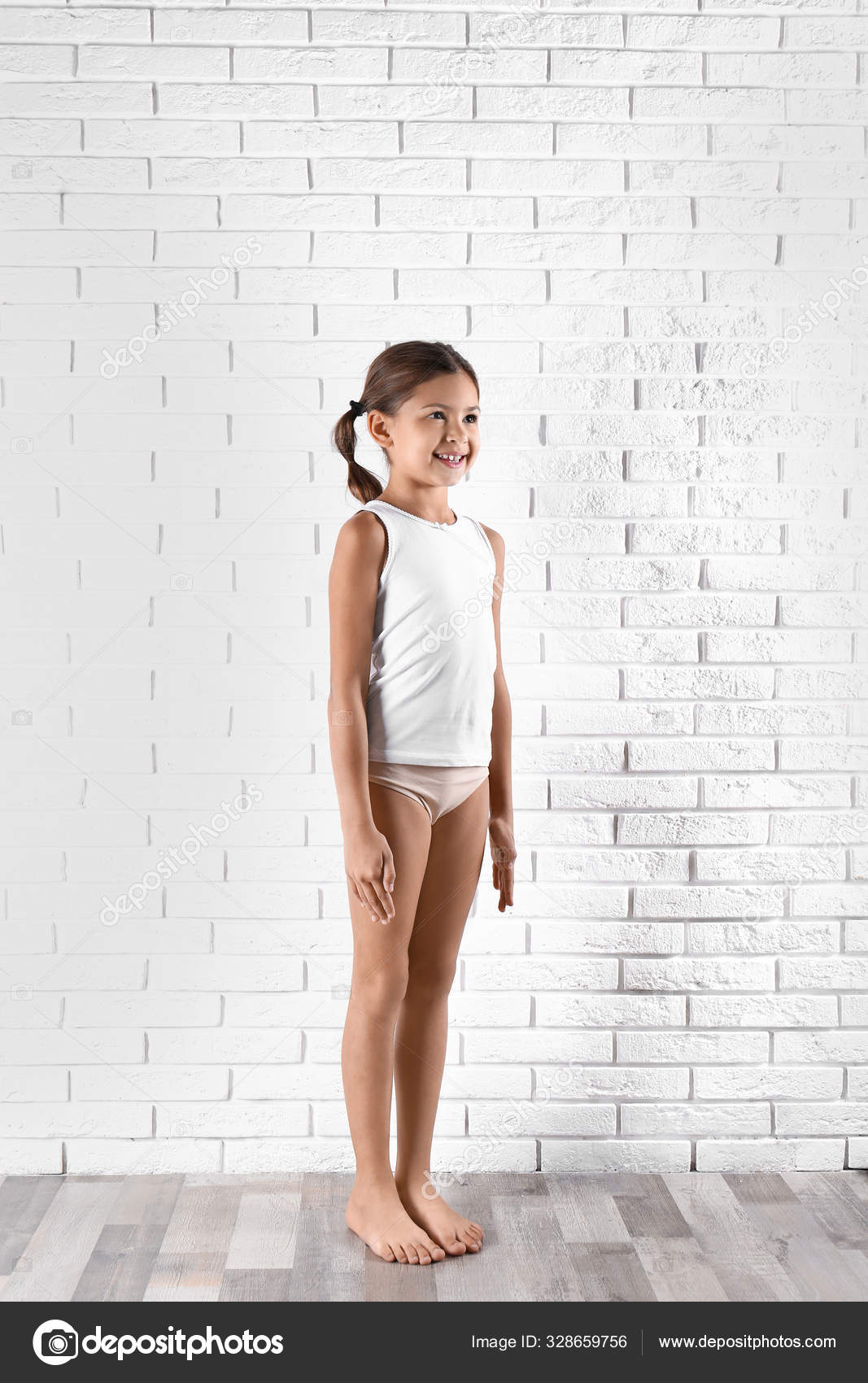 Cute little girl in underwear near white brick wall Stock Photo by  ©NewAfrica 328659756