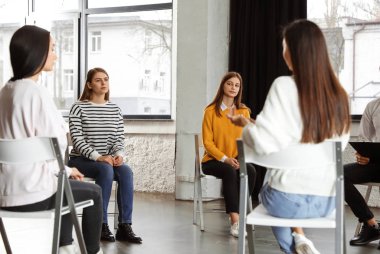 İçeride grup terapisinde hastalarla çalışan psikoterapist.