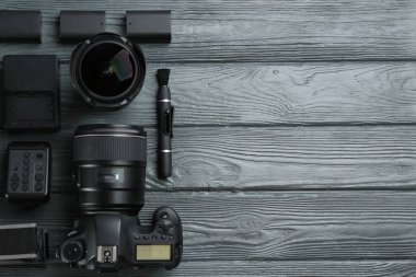 Gri ahşap masada profesyonel fotoğrafçı için ekipmanla düz kompozisyon. Metin için boşluk