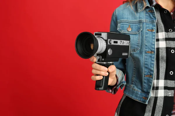 Vrouw met vintage videocamera op rode achtergrond, close-up. Spek — Stockfoto