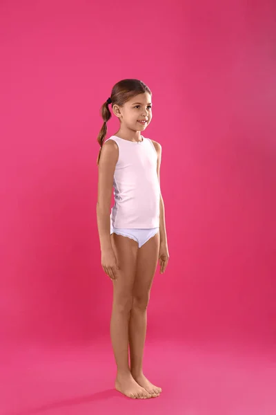 Милая маленькая девочка в нижнем белье на розовом фоне — стоковое фото