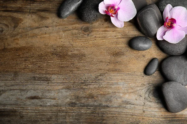Stenen Met Orchidee Bloemen Ruimte Voor Tekst Houten Achtergrond Plat — Stockfoto