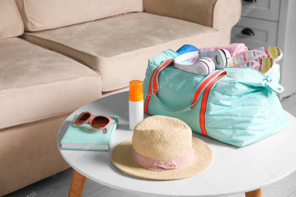 Bag and items for vacation on table in living room