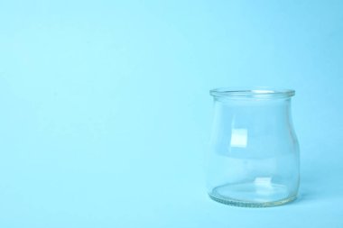 Açık mavi arkaplanda boş cam kavanoz aç, metin için boşluk