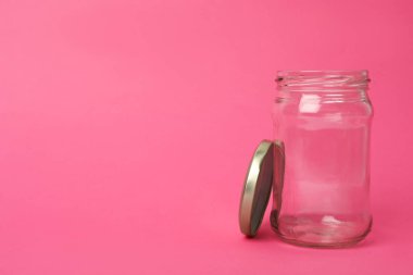 Boş cam kavanozu pembe arkaplanda aç, metin için boşluk