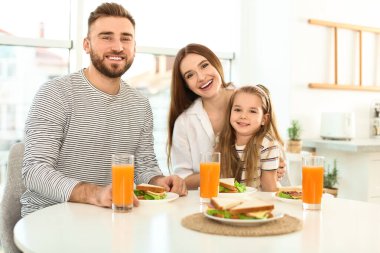 Mutlu bir aile kahvaltısını Kitche 'de sandviç masasında yapıyor.
