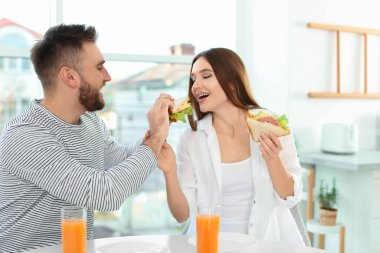 Mutlu çift Kitche 'deki masada sandviçlerini yiyor.
