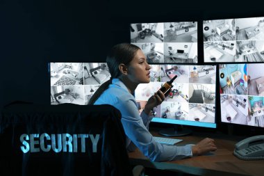 Mobil vericili güvenlik görevlisi modern CCTV 'yi izliyor. 
