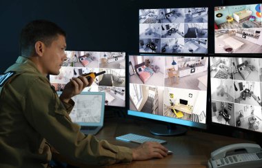 Mobil vericili güvenlik görevlisi modern CCTV 'yi izliyor. 